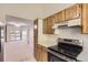 Bright kitchen with stainless steel stove and a view into the carpeted living room at 3558 S Depew St # 302, Denver, CO 80235