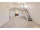 Bright living room with loft, stairs, entry door and glimpse of kitchen at 3558 S Depew St # 302, Denver, CO 80235