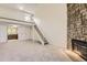Carpeted living room showcasing stairs to loft and stone fireplace at 3558 S Depew St # 302, Denver, CO 80235