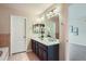 Bathroom featuring double sinks, granite countertops, and neutral tiling at 24288 E Brandt Ave, Aurora, CO 80016