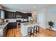 Modern kitchen with dark cabinetry, stainless steel appliances, granite counters, and a center island at 24288 E Brandt Ave, Aurora, CO 80016