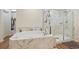 Elegant bathroom featuring soaking tub, glass shower, and marble-look finishes at 5737 Amarosa Dr, Parker, CO 80134