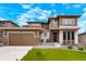 Inviting two-story home featuring a manicured lawn, stone accents, and attached two car garage at 5737 Amarosa Dr, Parker, CO 80134