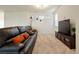 Inviting living room with a comfortable leather sofa, accent pillows, and a television on a stylish stand at 5737 Amarosa Dr, Parker, CO 80134