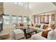 Open living room featuring a stone fireplace, large windows, and neutral toned decor at 5737 Amarosa Dr, Parker, CO 80134