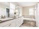 Luxury bathroom featuring dual sinks, a soaking tub, and modern finishes at 2879 Shadow Lake Rd, Lafayette, CO 80026