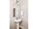 Stylish powder room featuring a pedestal sink, modern mirror, and bright lighting at 2879 Shadow Lake Rd, Lafayette, CO 80026