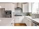 Well-lit kitchen with white cabinets, stainless steel appliances, and a gray tile backsplash at 2879 Shadow Lake Rd, Lafayette, CO 80026
