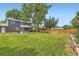 Lush green backyard featuring a wooden fence, seating area, and mature trees at 10826 Claire Ln, Northglenn, CO 80234