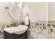 A quaint powder room featuring tile detail, a round mirror, and towel bar at 10826 Claire Ln, Northglenn, CO 80234