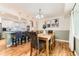Dining room with modern chandelier, hardwood floors, and views of the kitchen and backyard at 10826 Claire Ln, Northglenn, CO 80234