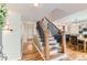 Bright entryway featuring hardwood floors, staircase with iron railings, and open access to dining area at 10826 Claire Ln, Northglenn, CO 80234