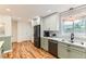 Bright kitchen with white cabinets, stainless steel appliances, and wood-look flooring at 10826 Claire Ln, Northglenn, CO 80234