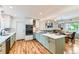Eat-in kitchen featuring stainless steel appliances, kitchen island, custom cabinets, and hardwood floors at 10826 Claire Ln, Northglenn, CO 80234