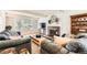 Comfortable living room with a fireplace, hardwood floors, large windows, and plush sofas at 10826 Claire Ln, Northglenn, CO 80234
