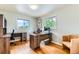 Well-lit home office features wood floors, two desks, and natural light from two windows at 10826 Claire Ln, Northglenn, CO 80234