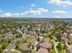 Serene aerial view of a suburban neighborhood with lush green trees and well-manicured lawns under a partly cloudy sky at 16753 W 61St Ln, Golden, CO 80403
