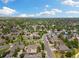 Extensive aerial shot of a leafy residential area with diverse housing styles and ample green spaces under a sunny, cloudy sky at 16753 W 61St Ln, Golden, CO 80403