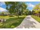Manicured community park walking path, featuring green grass, mature trees, and seating, perfect for outdoor enjoyment at 16753 W 61St Ln, Golden, CO 80403