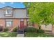 Charming townhouse with brick facade, red door, green wreath, and lovely front yard landscaping at 10693 W 63Rd Dr # 106, Arvada, CO 80004