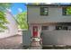 Inviting townhouse with a red front door, well-kept landscaping, and privacy fence at 10693 W 63Rd Dr # 106, Arvada, CO 80004