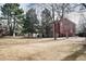 Exterior of a red condo building on a grassy lawn with mature trees and pathways at 2686 E Otero Pl # 12, Centennial, CO 80122