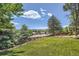 A spacious, well-maintained backyard with lush green lawn and mature trees at 11410 W 72Nd Pl, Arvada, CO 80005