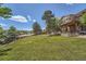 A large, green backyard features an upper deck and mature trees at 11410 W 72Nd Pl, Arvada, CO 80005
