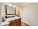 Bathroom features wood vanity, framed mirror, and closet with sliding doors at 11410 W 72Nd Pl, Arvada, CO 80005