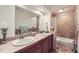 Bathroom featuring double sinks, tiled walls, and a shower/tub combo at 11410 W 72Nd Pl, Arvada, CO 80005