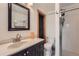 Updated bathroom with a dark vanity, modern sink, and walk-in shower at 11410 W 72Nd Pl, Arvada, CO 80005