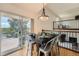 Elegant dining room features a modern light fixture, hardwood floors, and access to the outdoor deck at 11410 W 72Nd Pl, Arvada, CO 80005