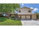 Charming two-story home with brick accents and a two-car garage, surrounded by mature trees and lush greenery at 11410 W 72Nd Pl, Arvada, CO 80005