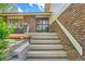 Inviting front porch with wood stairs and brick accents, leading to the front door with a decorative screen at 11410 W 72Nd Pl, Arvada, CO 80005
