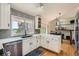 Bright kitchen boasts white cabinets, stainless steel appliances, and hardwood flooring at 11410 W 72Nd Pl, Arvada, CO 80005