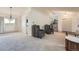 Open living area with plush carpet, designer chairs, and seamless flow to the kitchen and staircase at 11410 W 72Nd Pl, Arvada, CO 80005