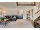 Cozy living room with a modern sofa, wet bar, and staircase to the second floor at 11410 W 72Nd Pl, Arvada, CO 80005