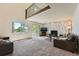 Spacious living room features a stone fireplace, large windows, and access to an outdoor deck at 11410 W 72Nd Pl, Arvada, CO 80005