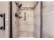Tiled shower featuring a handheld shower head, convenient grab bar, and modern tile at 11410 W 72Nd Pl, Arvada, CO 80005