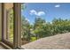 A window view showcasing the neighborhood with mature trees and a blue sky at 11410 W 72Nd Pl, Arvada, CO 80005