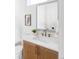 Chic powder room featuring modern fixtures, a decorative mirror, and wood vanity at 1683 N Zenobia St, Denver, CO 80204