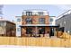 Modern brick home with a rooftop deck and a well-manicured lawn. The wooden fence adds charm at 1683 N Zenobia St, Denver, CO 80204