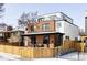 Stylish brick and white home featuring a rooftop deck, cozy front porch, and fenced yard at 1683 N Zenobia St, Denver, CO 80204