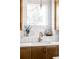 Charming kitchen sink with light wood cabinets, bronze hardware, white backsplash, and stainless faucet at 1683 N Zenobia St, Denver, CO 80204