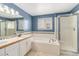 Well-lit bathroom with dual sinks, soaking tub and glass enclosed shower at 821 S 34Th Ave, Brighton, CO 80601