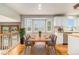 Dining room with natural light, hardwood floors, modern lighting, white cabinetry, and stainless steel dishwasher at 821 S 34Th Ave, Brighton, CO 80601