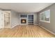 Bright living room featuring a cozy fireplace, built-in shelves and an open doorway to a utility room at 821 S 34Th Ave, Brighton, CO 80601