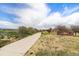 Well maintained concrete walking path with green spaces, signage, and manicured landscaping at 821 S 34Th Ave, Brighton, CO 80601