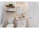 Cozy bathroom with a single sink vanity, a mirror, and floating shelves for storage at 2891 S Vaughn Way, Aurora, CO 80014