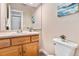 Bathroom featuring a wood vanity, a white toilet, and a large mirror at 2891 S Vaughn Way, Aurora, CO 80014